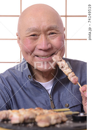 笑顔で焼き鳥を食べるシニア 笑顔で焼き鳥を食べるシニア 74149519