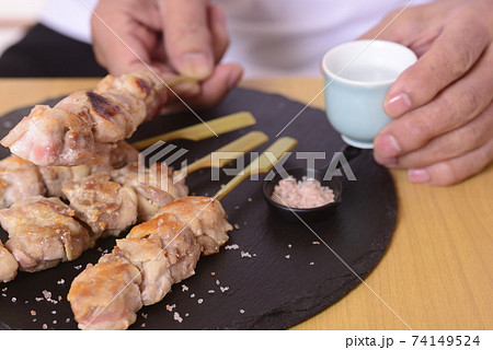 シニアの手に日本酒と焼き鳥 シニアの手に日本酒と焼き鳥 74149524