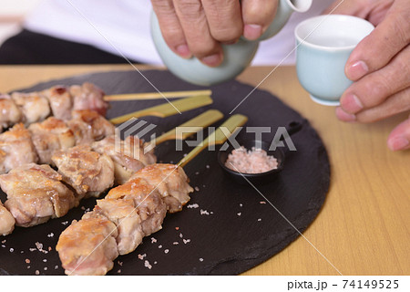 シニアの手に日本酒と焼き鳥 シニアの手に日本酒と焼き鳥 74149525