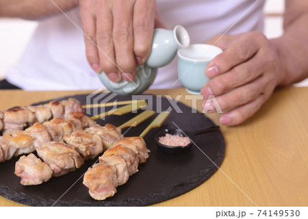 シニアの手に日本酒と焼き鳥 シニアの手に日本酒と焼き鳥 74149530