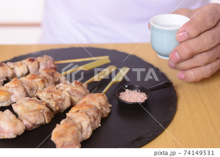 シニアの手に日本酒と焼き鳥 シニアの手に日本酒と焼き鳥 74149531