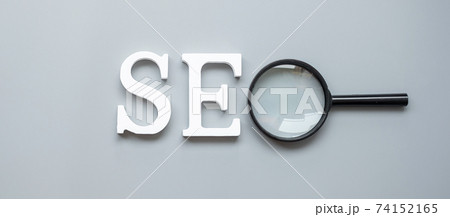 SEO (Search Engine Optimization) text and magnifying glass on gray background. Idea, Vision, Strategy, Analysis, Keyword and Content concept 74152165