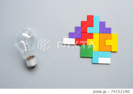 lightbulb with colorful wood puzzle piece on gray background. New Idea, Creative, Innovation, Imagination, inspiration, Solution, Strategy and Logic concept lightbulb with colorful wood puzzle piece on gray background. New Idea, Creative, Innovation, Imagination, inspiration, Solution, Strategy and Logic concept 74152190