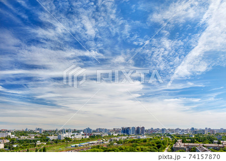 Panorama of the city under a high beautiful blue sky with light white curly clouds. Panorama of the city under a high beautiful blue sky with light white curly clouds. 74157870