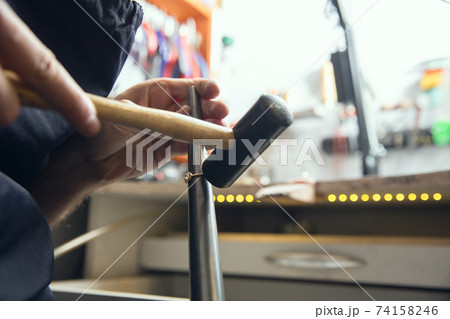 Close up hands of jeweller, goldsmiths making of golden ring with gemstone using professional tools. 74158246