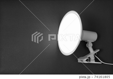 Glowing flat high power LED lamp on a clothespin on a gray background. Glowing flat high power LED lamp on a clothespin on a gray background. 74161805