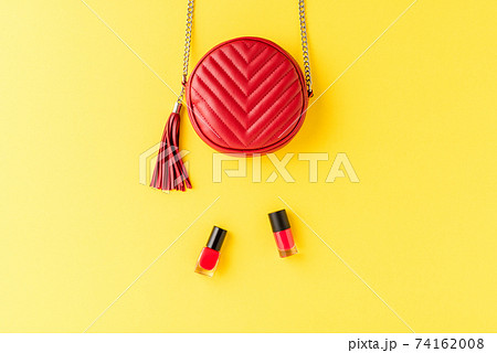 Red leather purse on background with nail polishes. Fashion and beauty background. Flat lay Red leather purse on background with nail polishes. Fashion and beauty background. Flat lay 74162008