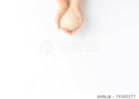 Female hands holding white rice grains isolated on white background with copyspace. Top view 74162277