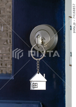 Open door to a new home with key and home shaped keychain. Mortgage, investment, real estate, property and new home concept 74168857