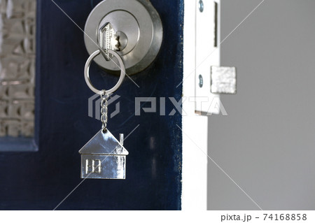 Open door to a new home with key and home shaped keychain. Mortgage, investment, real estate, property and new home concept 74168858