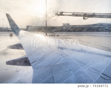 de-icing of aircraft wing by chemicals in airport de-icing of aircraft wing by chemicals in airport 74169772