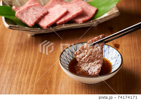焼肉をタレにつける 74174171