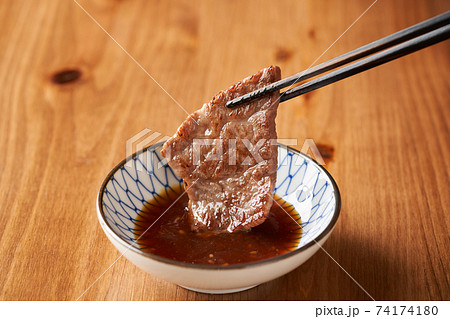 焼肉をタレにつける 焼肉をタレにつける 74174180