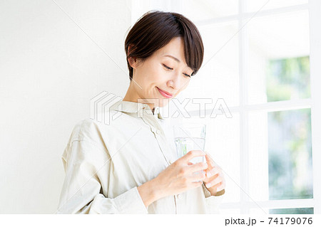 窓際で水を飲む女性 窓際で水を飲む女性 74179076