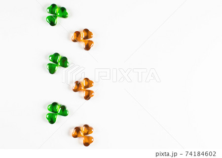Shamrock symbols made of green and orange glass hearts on white background Shamrock symbols made of green and orange glass hearts on white background 74184602