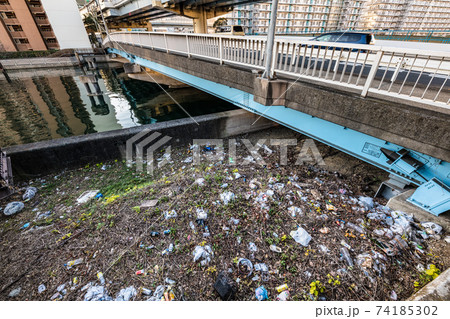運河橋下空地に捨てられているゴミの写真素材