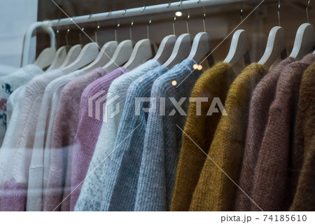 Closeup of woolen pullovers set on hangers in a fashion store showroom Closeup of woolen pullovers set on hangers in a fashion store showroom 74185610
