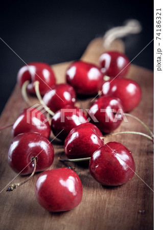 Fresh cherries on a wooden cutting board Fresh cherries on a wooden cutting board 74186321
