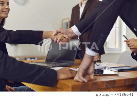 Business partners shaking hands after successful negotiations and approved deal Business partners shaking hands after successful negotiations and approved deal 74186641