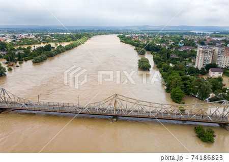 Aerial view of flooded houses with dirty water of Dnister river in Halych town, western Ukraine. Aerial view of flooded houses with dirty water of Dnister river in Halych town, western Ukraine. 74186823
