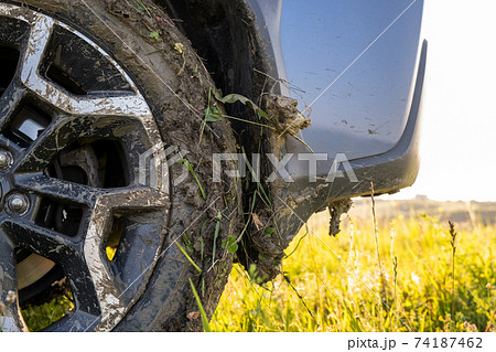 Close up of dirty off road car wheels with dirty tires covered with yellow mud. Close up of dirty off road car wheels with dirty tires covered with yellow mud. 74187462