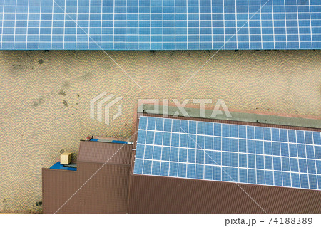 Aerial view of solar power plant with blue photovoltaic panels mounted of industrial building roof. 74188389