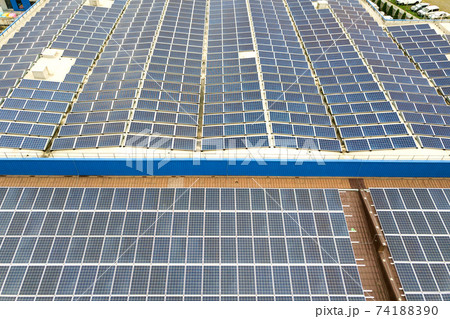 Aerial view of solar power plant with blue photovoltaic panels mounted of industrial building roof. 74188390