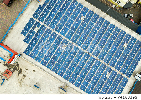 Aerial view of solar power plant with blue photovoltaic panels mounted of industrial building roof. 74188399