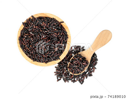 dark violet rice berry with wooden bowl and spoon isolated on white background dark violet rice berry with wooden bowl and spoon isolated on white background 74189010