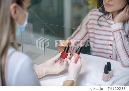 Customer choosing the color of a nail polish 74190283