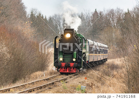 Steam train moves at autumn day time. Steam train moves at autumn day time. 74191168
