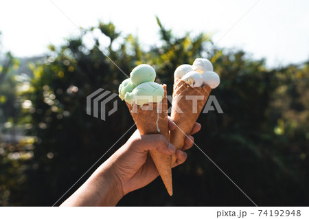 Ice cream cone,Ice cream in hand during the hot day Ice cream cone,Ice cream in hand during the hot day 74192948