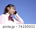 スマートフォンで連絡する学生　青空 74193032