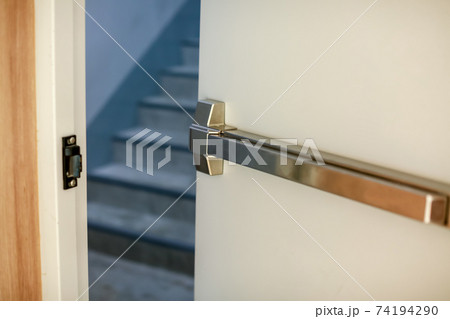 Emergency fire exit door. Closed up latch and rusty door handle of emergency exit. Emergency fire exit door. Closed up latch and rusty door handle of emergency exit. 74194290