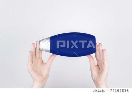 Chemical components of the shampoo. A woman's hand holds a black jar of shampoo. Place for text. Conception of the harm of chemical cosmetics or the benefits of organic chemicals for home Chemical components of the shampoo. A woman's hand holds a black jar of shampoo. Place for text. Conception of the harm of chemical cosmetics or the benefits of organic chemicals for home 74195858