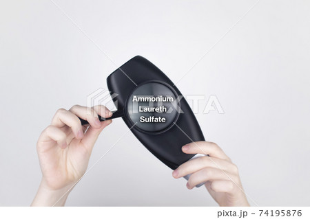 Chemical or natural components of the shampoo, ingredients and composition of the hair product. Female hands hold a black shampoo jar and a magnifying glass. Place for text Chemical or natural components of the shampoo, ingredients and composition of the hair product. Female hands hold a black shampoo jar and a magnifying glass. Place for text 74195876