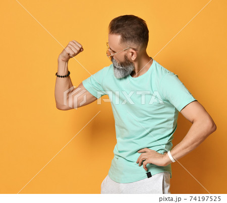 Brutal bearded man showing muscle power gesture 74197525
