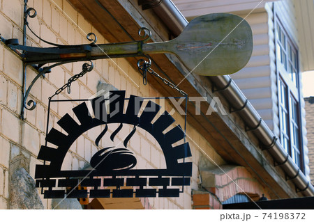 A metal sign above a baked goods store. A metal sign above a baked goods store. 74198372