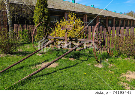 An old rusty chariot near the fence. 74198445