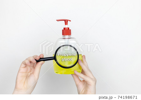 A woman examines the harmful ingredients of the liquid soap a magnifying glass. Harmful composition of ingredients. Means with Propylene glycol A woman examines the harmful ingredients of the liquid soap a magnifying glass. Harmful composition of ingredients. Means with Propylene glycol 74198671