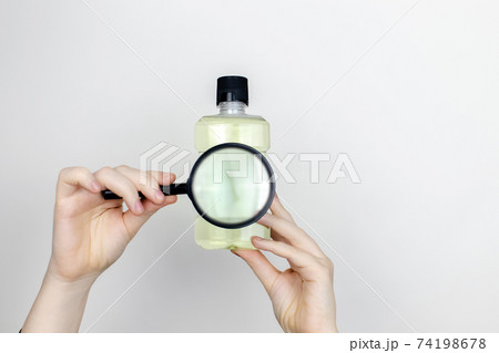 A woman is holding mouthwash. Place for your text. The concept of hazardous substances in cosmetics and household chemicals 74198678