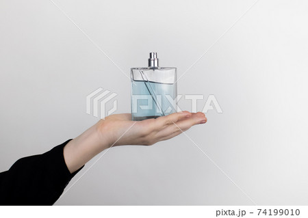 A woman is holding an perfume. Place for your text. The concept of hazardous substances in cosmetics and household chemicals A woman is holding an perfume. Place for your text. The concept of hazardous substances in cosmetics and household chemicals 74199010