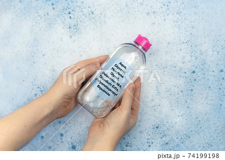 A bottle of micellar water floating in soapy water. Harmful composition of ingredients. The concept of hazardous substances in cosmetics and household chemicals 74199198