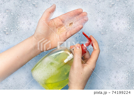 Bottles of detergents float in the foam. The concept of the dangers of household chemicals. Sodium laureate, parabens, sulfates and other chemical compounds in the foam. Liquid soap in a yellow jar Bottles of detergents float in the foam. The concept of the dangers of household chemicals. Sodium laureate, parabens, sulfates and other chemical compounds in the foam. Liquid soap in a yellow jar 74199224