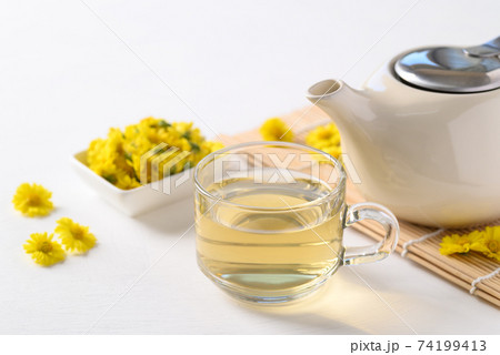 Chrysanthemum flower tea in a cup and teapot Chrysanthemum flower tea in a cup and teapot 74199413