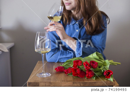 Lisbian girl, with a bouquet of flowers and a glass of wine in natural soft lighting. The concept of Lisbian girl, with a bouquet of flowers and a glass of wine in natural soft lighting. The concept of 74199493