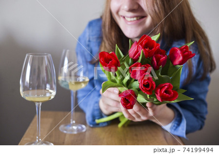 Lisbian girl, with a bouquet of flowers and a glass of wine in natural soft lighting. The concept of 74199494