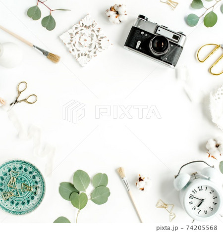 Working space with ceramic sheet monstera, retro camera, eucalyptus leaf, accessories on white background. Flat position. Top view Working space with ceramic sheet monstera, retro camera, eucalyptus leaf, accessories on white background. Flat position. Top view 74205568