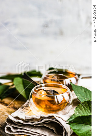 Tea time concept with modern double glass cup with black tea drink served on white stone background with copy space 74205854
