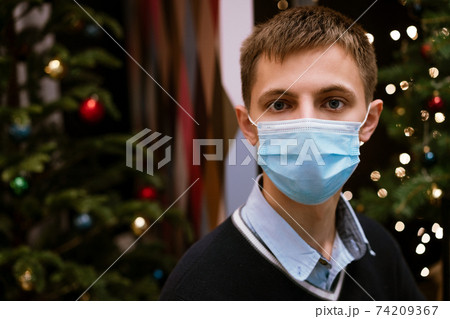 portrait of a young man in a medical mask on a bokeh background portrait of a young man in a medical mask on a bokeh background 74209367
